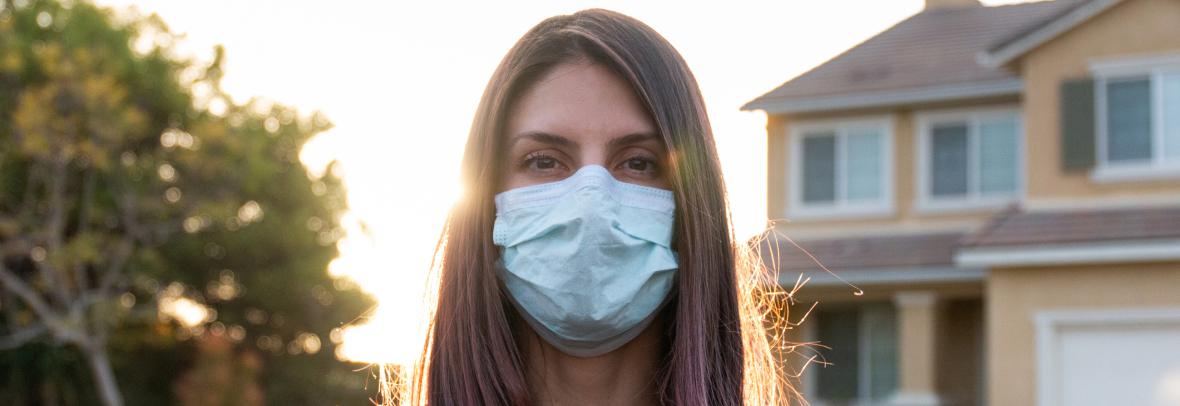 woman wearing face mask outside a house