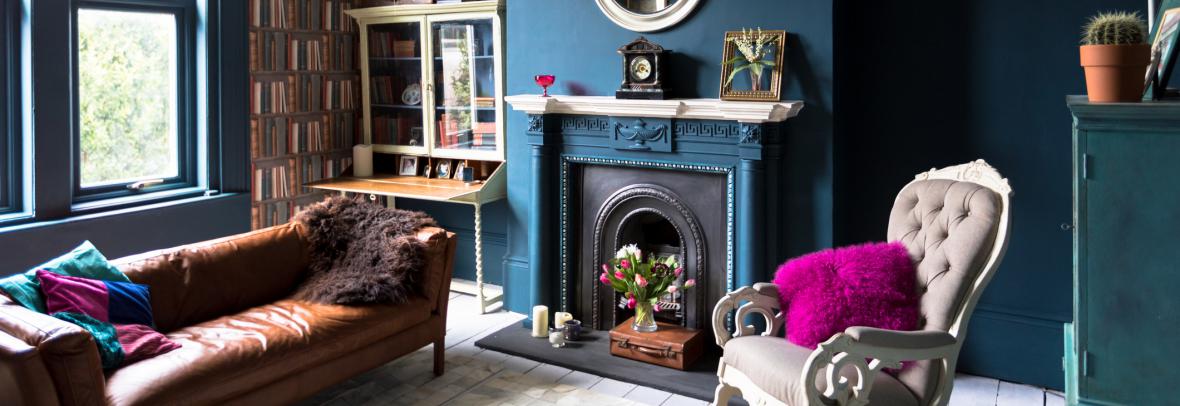 Living room with a pink pillow, blue walls and other offbeat furnishings