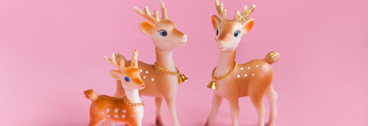 Pink Christmas Background with Vintage Reindeer Family - stock photo  Vintage Christmas background, conceptual family, no people. Plastic reindeer family Christmas decorations on pink background. Conceptual image for mother and father, family with one child, and family themes. Copy space.