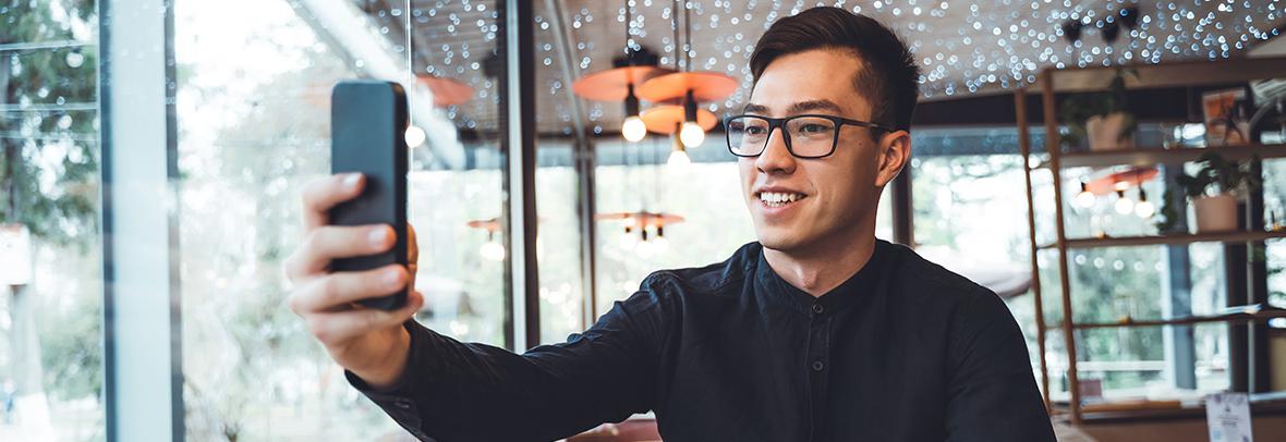 Photo of a man taking video with his phone