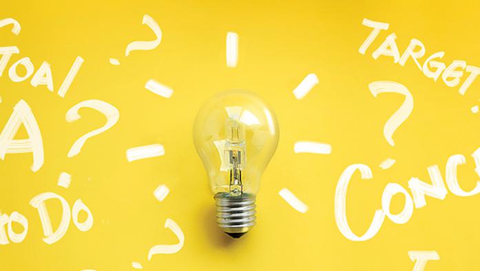 Photo illustration of a light bulb with white writing around it on yellow background
