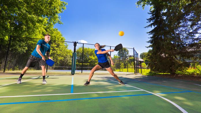 A couple plays on a pickleball court