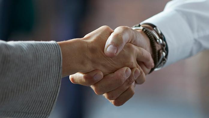 Photo of two business people shaking hands
