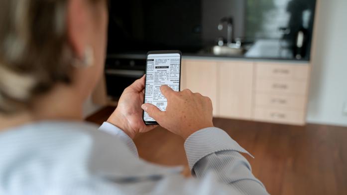 woman from back looking at property listing on phone