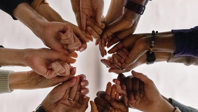 Photo of group of business people grasping hands as a team
