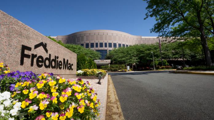 Front sign of Freddie Mac building in Virginia. Sign is surrounded by flowers and a blue sky