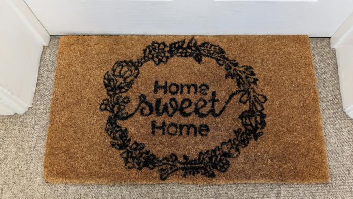 Home Sweet Home welcome mat with shoes at front door