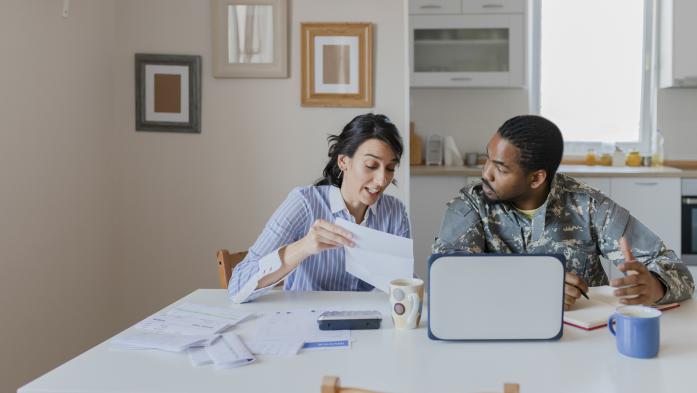 Military home buyer working with agent at kitchen table 