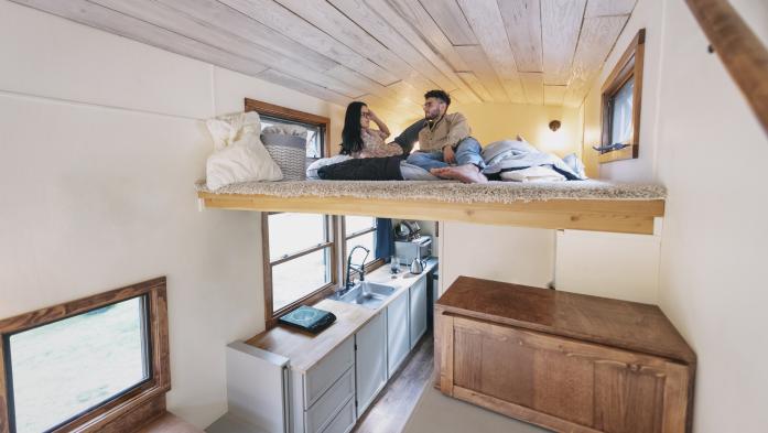 Couple in loft bed inside a tiny home