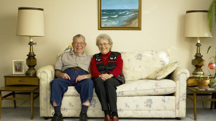 Older couple sitting on couch smiling