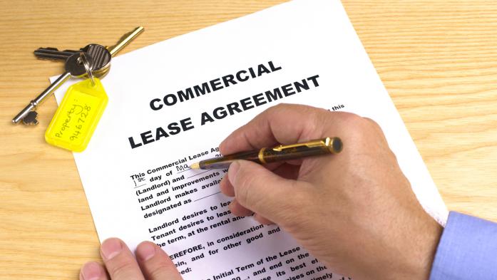 Man's hand signing lease agreement