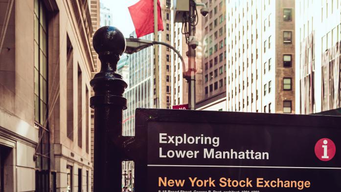 Wall Street photo with sign that says exploring lower Manhattan and New York Stock Exchange