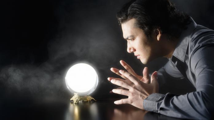 Man stares into a glowing crystal ball